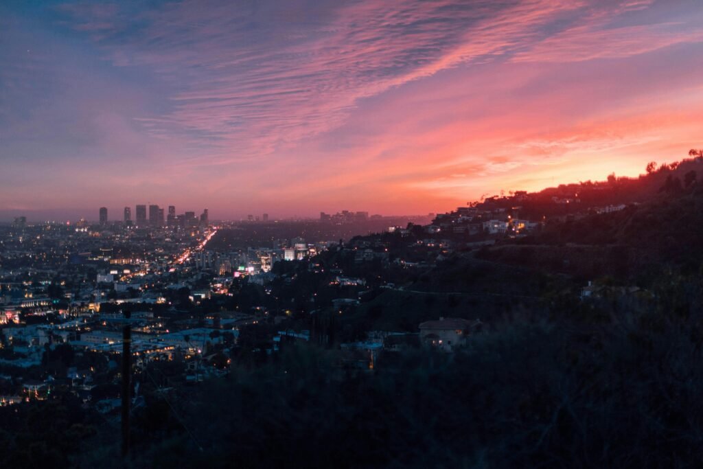 Capture of the vibrant Los Angeles skyline under a dramatic sunset sky.